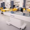 Medical students learn in a simulation lab with an interactive table displaying skeletal anatomy.